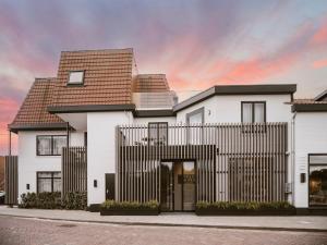 a white house with a black fence at Strandhotel Domburg in Domburg