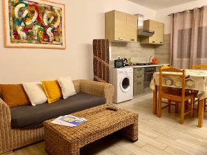 a living room with a couch and a table and a kitchen at Ca GIOgió in Santa Maria