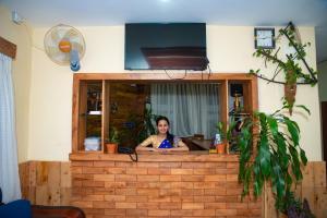 una mujer sentada en un mostrador en una habitación en Hotel Olympus Pokhara, en Pokhara
