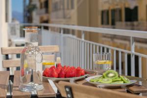 uma mesa com dois pratos de fruta e uma garrafa de sumo em Callisto Apartment Corfu em Corfu Town