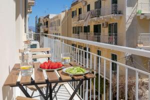 uma mesa com um prato de fruta numa varanda em Callisto Apartment Corfu em Corfu Town