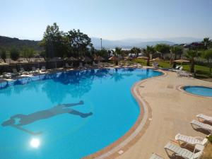 a swimming pool at a resort with lounge chairs at Lakeside Garden Holiday Village in Bogazici