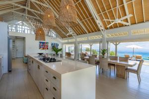 an open kitchen and dining room with a view of the ocean at Casa del Mar in Nusa Lembongan