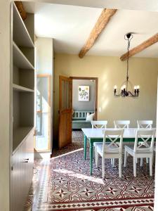 a dining room with a green table and white chairs at Charming Farmhouse in Provence in Cavaillon