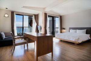 Schlafzimmer mit einem Bett, einem Schreibtisch und Fenstern in der Unterkunft 畫日風尚會館Sinasera Resort in Changbin