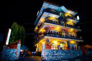 un edificio alto con balcones y luces. en Hotel Olympus Pokhara, en Pokhara