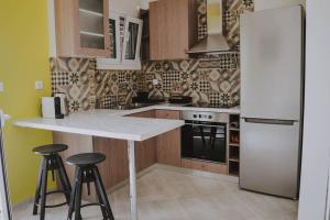 a kitchen with a refrigerator and two bar stools at Blue in Green North in Kastrosikia
