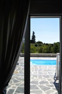 a view of a swimming pool through a glass door at Blue in Green North in Kastrosikia +9 photos