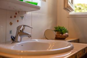 un lavandino con rubinetto e specchio di Buena Ventura Villa a Cala'n Bosch