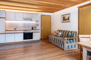 a kitchen and a living room with a couch at Adlerhorst Amsel in Santa Valpurga