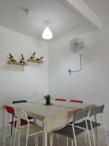 a white dining room table with chairs and a fan at Wong Bentong Makmur Homestay in Bentong