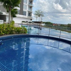 uma grande piscina azul em frente a um edifício em KULAI IOI MALL D'Putra Suites Near JPO Senai Airport 