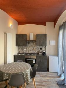 a kitchen with a table and chairs in a room at Maison de Cavour in Rivarolo Canavese