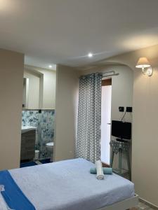 a bedroom with a bed and a bathroom with a sink at Maison de Cavour in Rivarolo Canavese