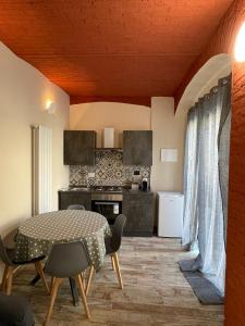 a room with a table and chairs and a kitchen at Maison de Cavour in Rivarolo Canavese