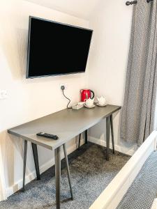 a table in a room with a tv on a wall at Broadford House Skye in Broadford