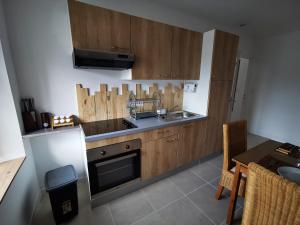 a kitchen with wooden cabinets and a sink and a table at Le Nica in Trélazé