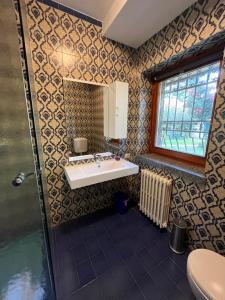 a bathroom with a sink and a mirror at Bella Vita Guesthouse -parcheggio privato interno in Arona