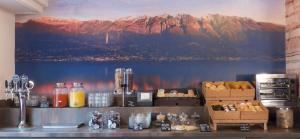 a counter with a mural of mountains on the wall at B&B 7 Vizi in Col&agrave; di Lazise