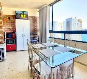 a dining room with a table with chairs and a tv at LuxBenidorm in Benidorm