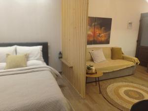 - une chambre avec un lit et un canapé dans l'établissement The family's house, à Tríkala