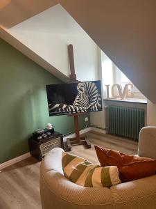 ein Wohnzimmer mit einem Sofa und einem Flachbild-TV in der Unterkunft Appartement Cosy et charmant in Saint Lo