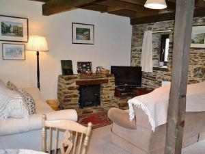 a living room with a couch and a fireplace at Mill Cottage in Fowey