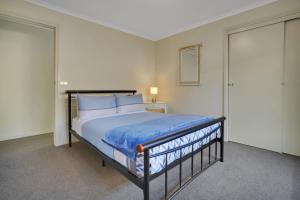 a bedroom with a bed and two sliding glass doors at Serendipity in Port Fairy