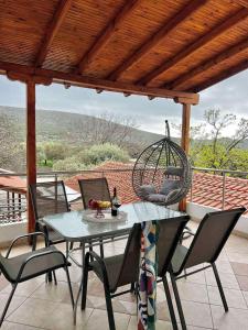 a patio with a table and chairs and a swing at Veni's Apartments in Potos