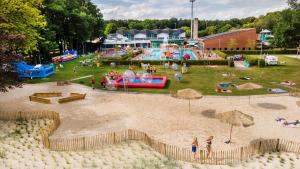 a park with a playground with people playing in the sand at Hössensportzentrum in Westerstede