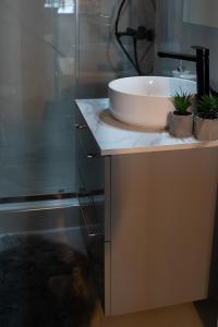 a bathroom with a sink and a glass shower at Triantos Guesthome Studio in Tripolis