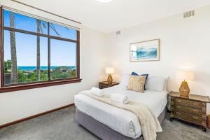 a bedroom with a bed and a window at The Lookout in Coffs Harbour