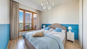 a blue and white bedroom with a bed and a window at Olympic Park I, Sun & Snow in Kołobrzeg