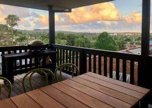 een houten tafel en stoelen op een balkon met uitzicht bij On the Hillside in Coffs Harbour