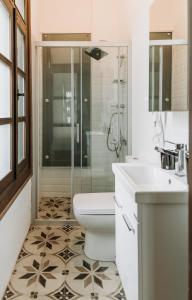 a bathroom with a shower and a toilet and a sink at Nill's Stone House otel in Çeşme