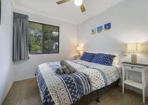 a white bedroom with a bed and a window at Ocean Sands 5 in Sawtell