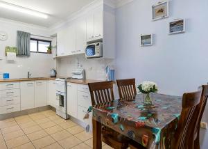 a kitchen with a table and chairs in a kitchen at Ocean Sands 5 in Sawtell