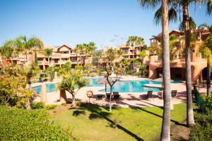 Blick auf ein Resort mit Pool und Palmen in der Unterkunft Where everyone is welcome in Estepona