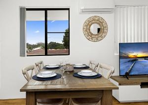 a dining room with a wooden table and a tv at Blue Gem in Sawtell +2 photos