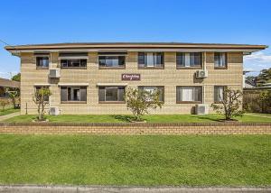 a large brick house with trees in front of it at Blue Gem in Sawtell