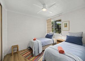 - une chambre avec 2 lits et un ventilateur de plafond dans l'établissement Hoppy's Place, à Sawtell