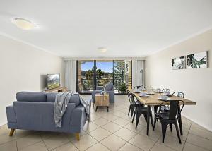 un soggiorno con divano blu e tavolo di Ocean Pines a Nambucca Heads