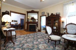 a living room with a table and chairs and a fireplace at Beauclaires Bed & Breakfast in Cape May