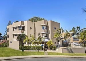 un grande edificio con palme di fronte di Ocean Pines a Nambucca Heads