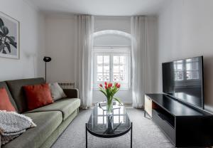 uma sala de estar com um sofá e uma televisão em Aspasios Calle Mayor Apartments em Madri