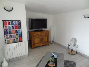 sala de estar con TV en un armario de madera en Gîte de l Alouette (3 Etoiles), en Grainville-Ymauville