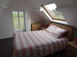 1 dormitorio con 1 cama y 2 ventanas en Gîte de l Alouette (3 Etoiles), en Grainville-Ymauville