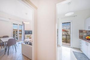 a white kitchen and dining room with a table at Tenniside view in Ágios Rókkos