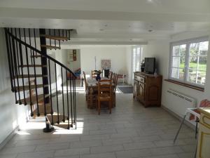 un salon avec un escalier en colimaçon et une salle à manger dans l'établissement Gîte de l Alouette (3 Etoiles), à Grainville-Ymauville