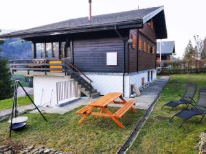 a house with a picnic table and chairs in front of it at Ferienwohnung im Chalet am Bach in Schwarzsee